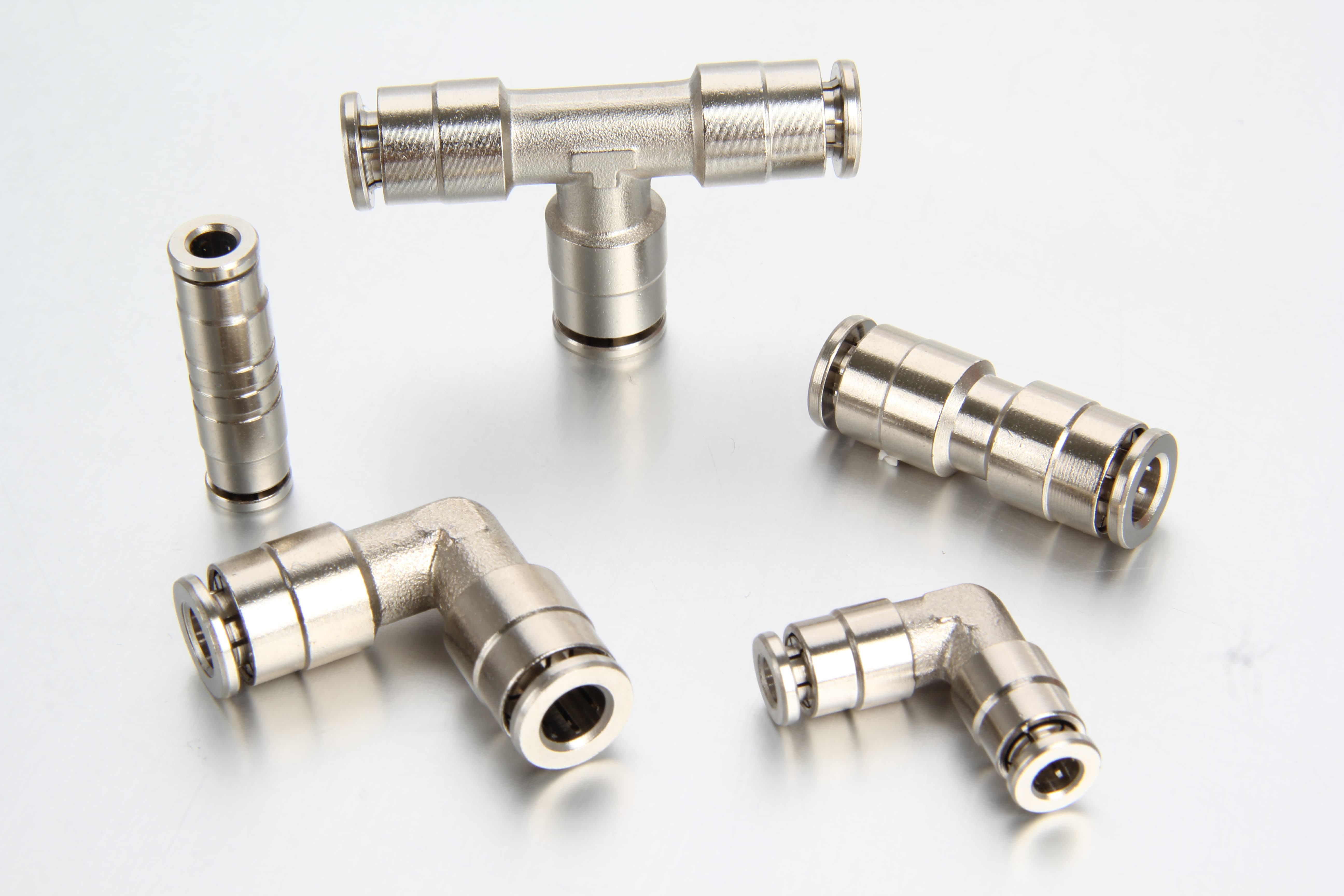 quick-connect-push-in-fittings-central-lubrication-systems A collection of high-pressure quick-connect and push-in fittings, including elbows, tees, Y unions, and non-return valves, arranged for automatic centralized lubrication systems.