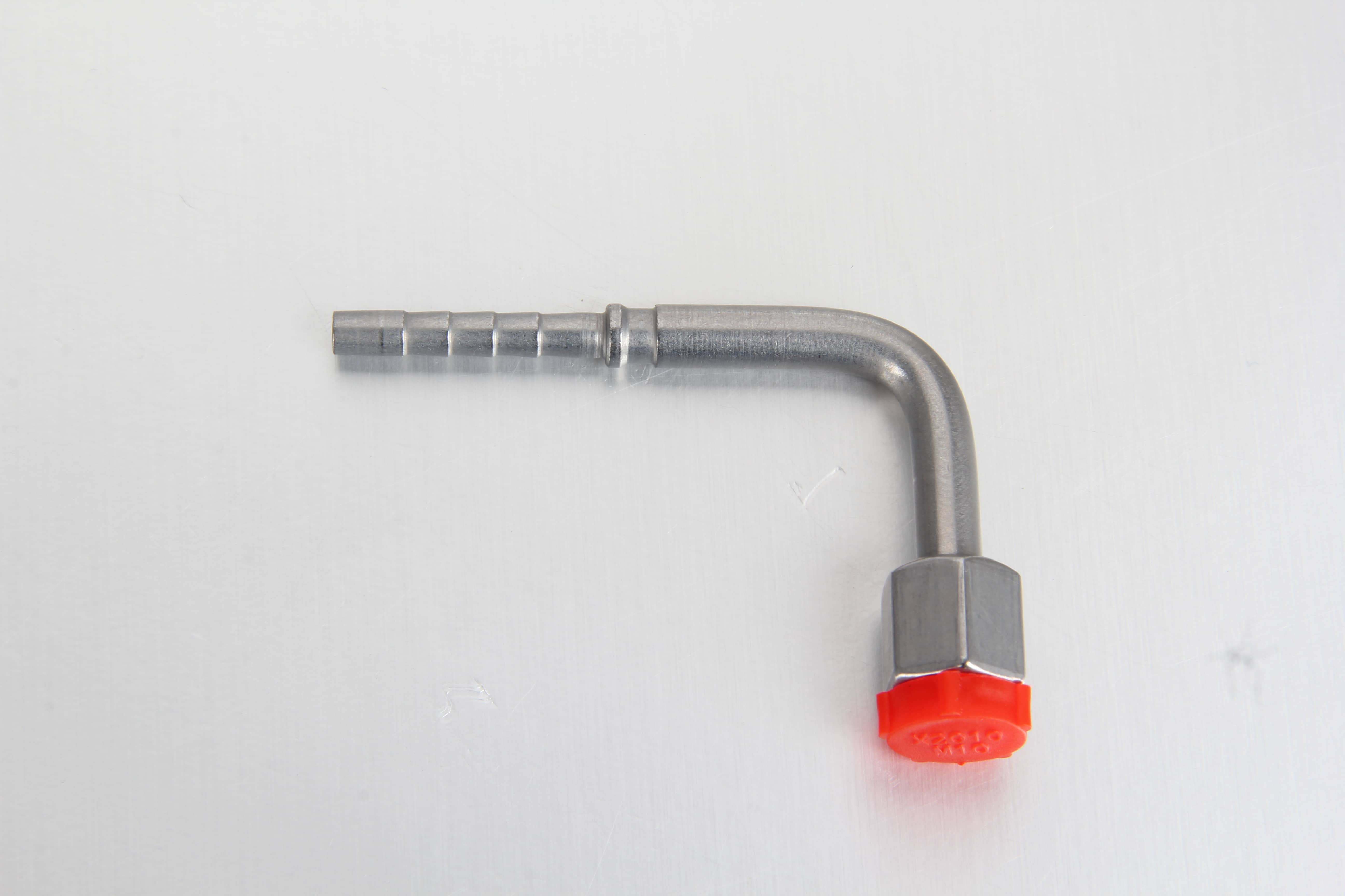  A real-world application photo of a 90-degree elbow DKOLL metric swivel fitting connecting a flexible 6mm grease hose to a progressive lubrication divider block.