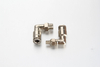 High-pressure progressive feeder block assembly in an industrial machinery setup with multiple plated brass swivel elbow push-in connectors guiding flexible lubrication tubes.
