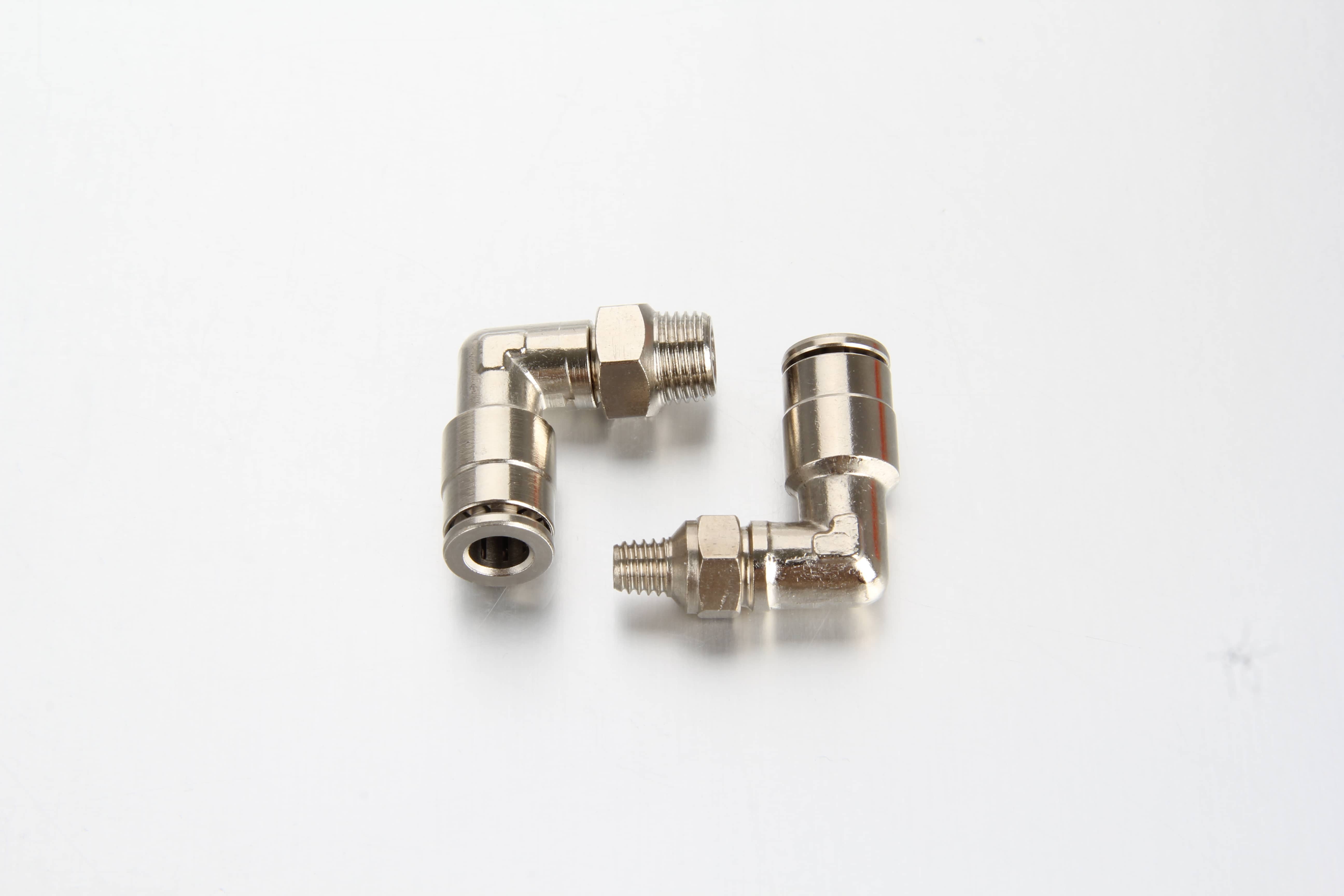 High-pressure progressive feeder block assembly in an industrial machinery setup with multiple plated brass swivel elbow push-in connectors guiding flexible lubrication tubes.