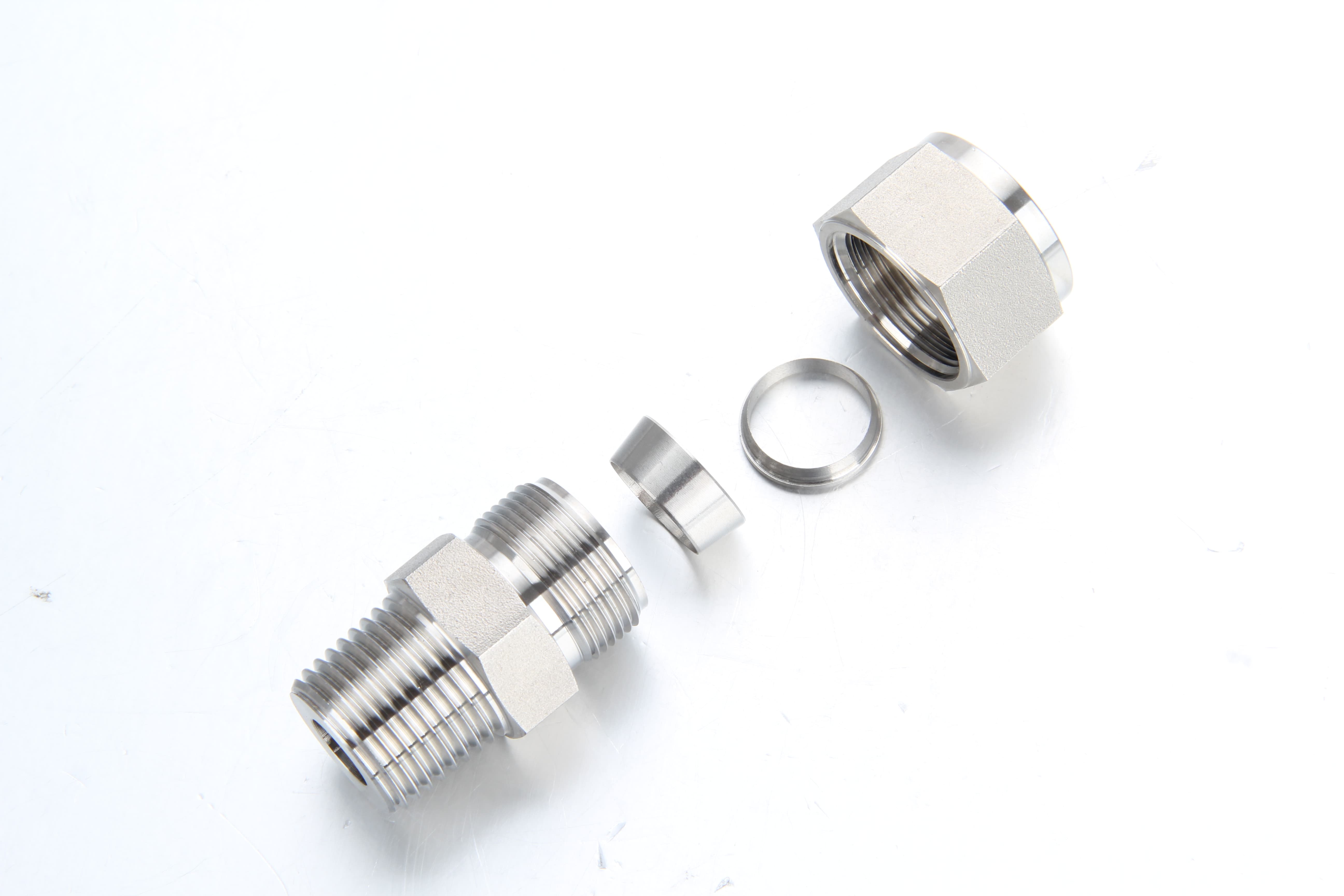 Exploded component view showing the fitting body, front ferrule, back ferrule, and nut assembly.