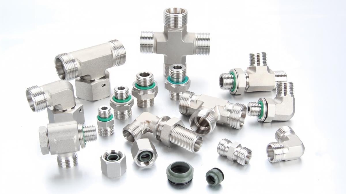 A professional gallery showcase of stainless steel DIN 2353 and ISO 8434-1 compliant hydraulic fittings, including tees, crosses, elbows, studs, and DOZ elastomeric soft-seal components