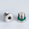 A real-world application photo showing multiple DIN 908 M10x1 soft sealing screw plugs blocking unused outlet ports flush on an automated grease progressive distributor.