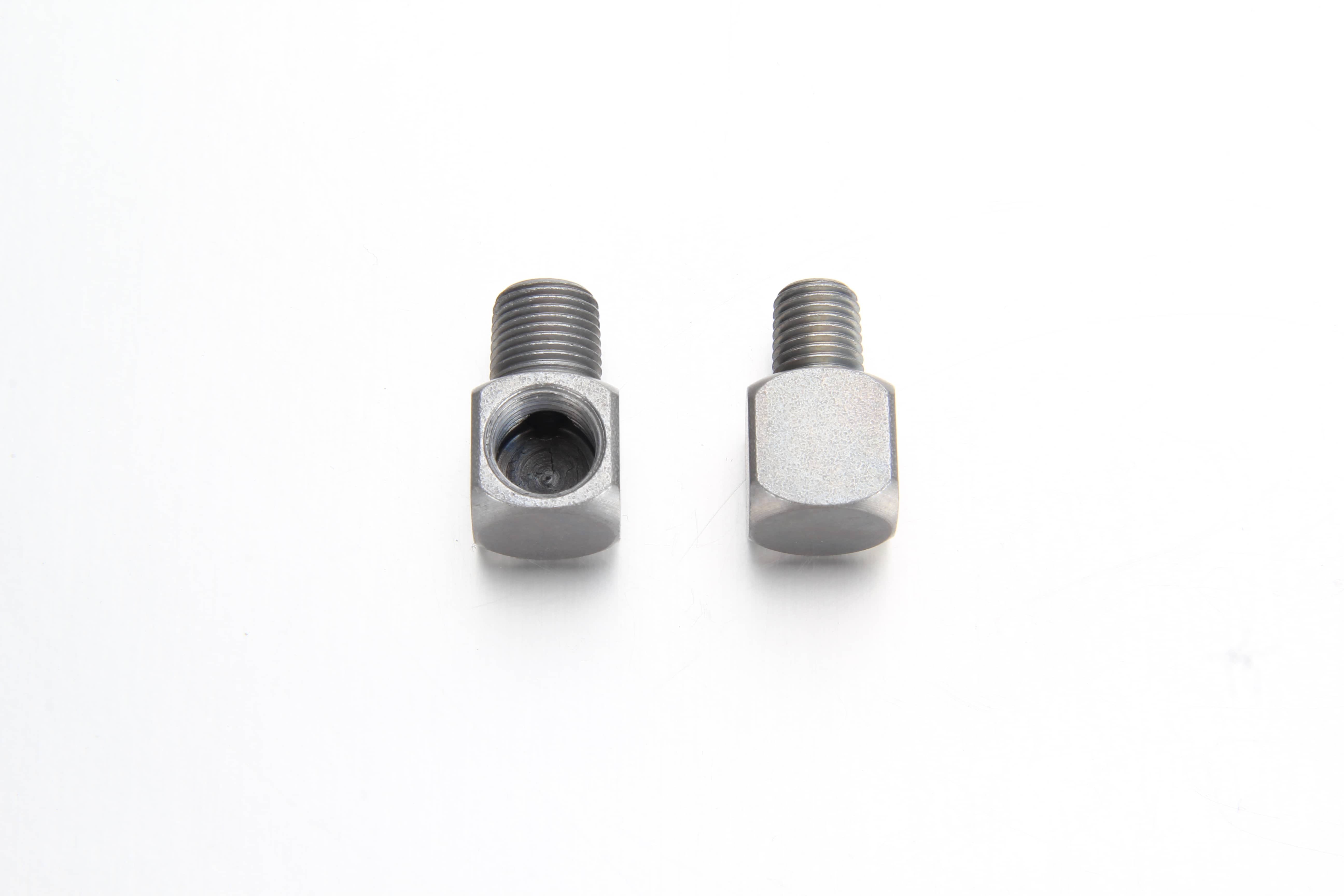 A zinc-plated 90 degree male-to-female thread adapter installed directly into a heavy industrial machine bearing block housing to clear tight frame spaces.