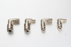 Close-up of a plated brass 90 degree male grease line fitting showing the precision-machined threads and internal gripping collet.